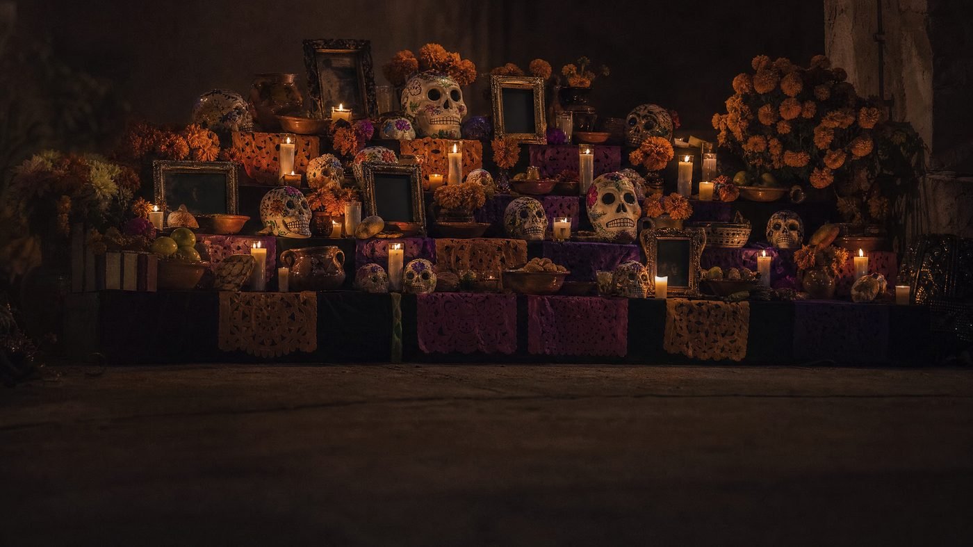 Altar zum Día de los Muertos mit Ringelblumen, Zuckerschädeln und brennenden Kerzen