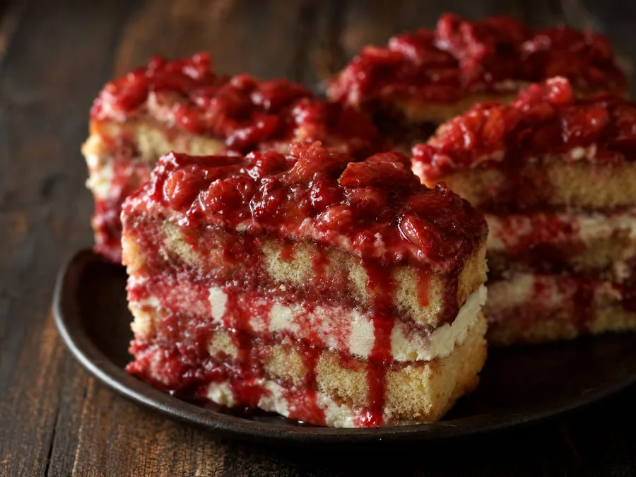 Biskuitschnitten mit Vanillecreme und rot herablaufender Erdbeermasse