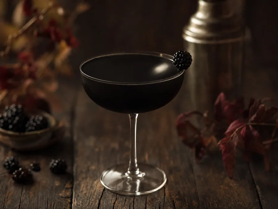 Tiefschwarzer Cocktail in einer Coupette